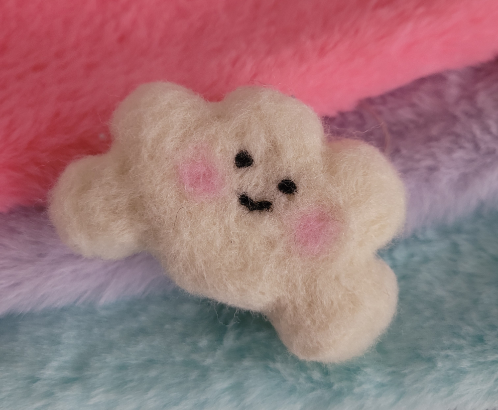 A needle felted kawaii happy face cloud.