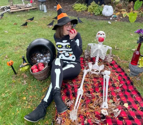 Library Monster having a proper picnic with her five foot adjustable skeleton on a plaid blanket in the front yard before trick 'r treating starts.